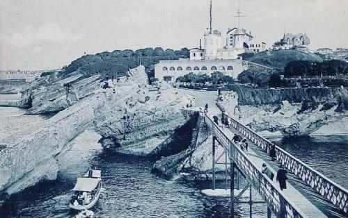 Biarritz. Vue vers l’ Attalaye. Le bateau de promenade passe sous la Roche percée