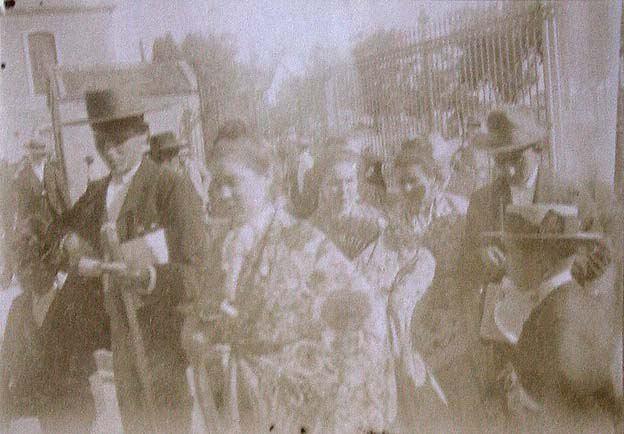 (Personas con trajes típicos a la entrada de una iglesia de Sevilla)