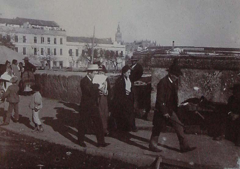 (Personas paseando por el puente de Triana de Sevilla)