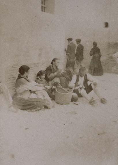 (Grupo de campesinos sentados en una calle)