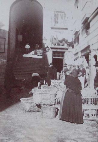 (Puestos de mercado en los aledaños del arco de cuchilleros de la Plaza Mayor de Madrid)