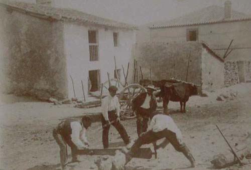 (Hombres cortando un tronco con un serrucho)