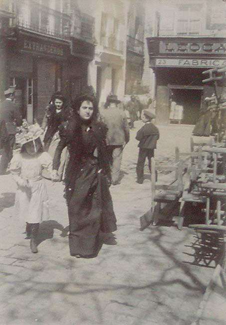 (Mujer con niña paseando por una calle)