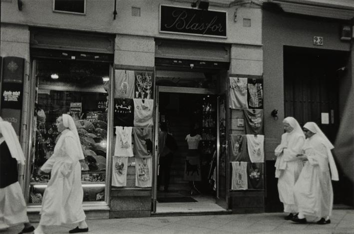 Monjas paseando delante de un comercio