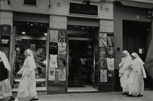 Monjas paseando delante de un comercio