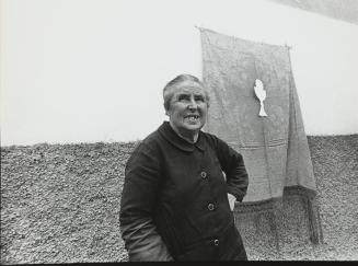 Mujer junto a bandera con símbolo eucarístico