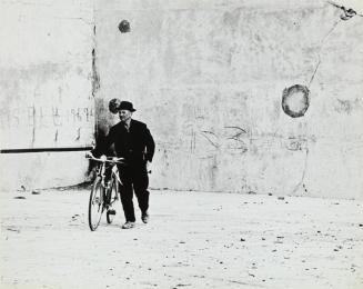 Hombre con bicicleta en frontón