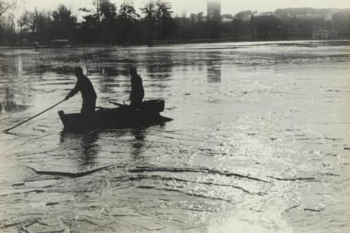 Dos hombres navegando un río en una barca