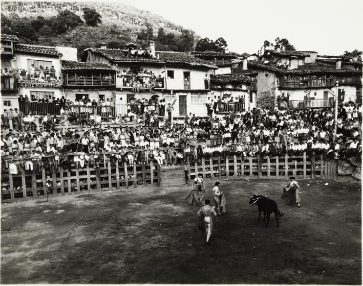 Corrida de toros en una plaza rodeada de casas