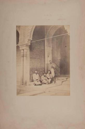 Grupo de cuatro hombres posando junto a la puerta de un patio de la Alhambra