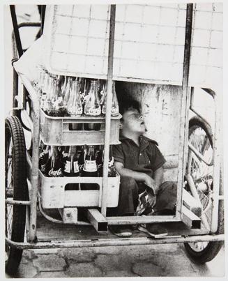 Niño durmiendo en un carro de transporte de bebidas