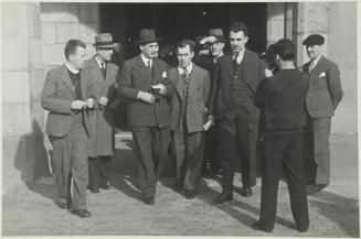 (Grupo de hombres saliendo de un edificio)