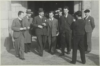 (Grupo de hombres saliendo de un edificio)