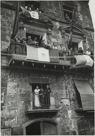 (Público asomado a las ventanas durante un desfile militar))