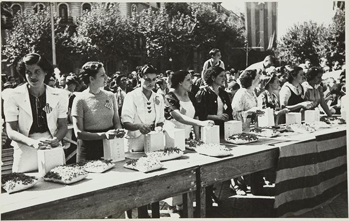 (Grupo de mujeres ante una mesa con regalos)