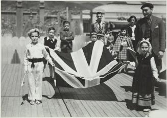 (Niños con trajes vascos portando una bendera vasca)