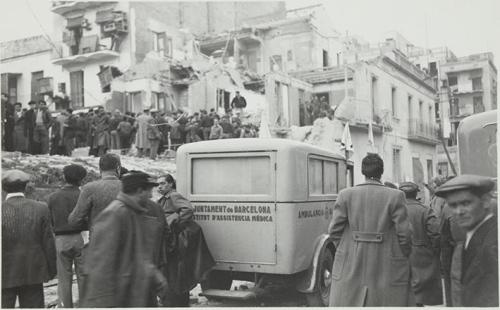 (Ambulancia en una calle bombardeada atestada de gente)